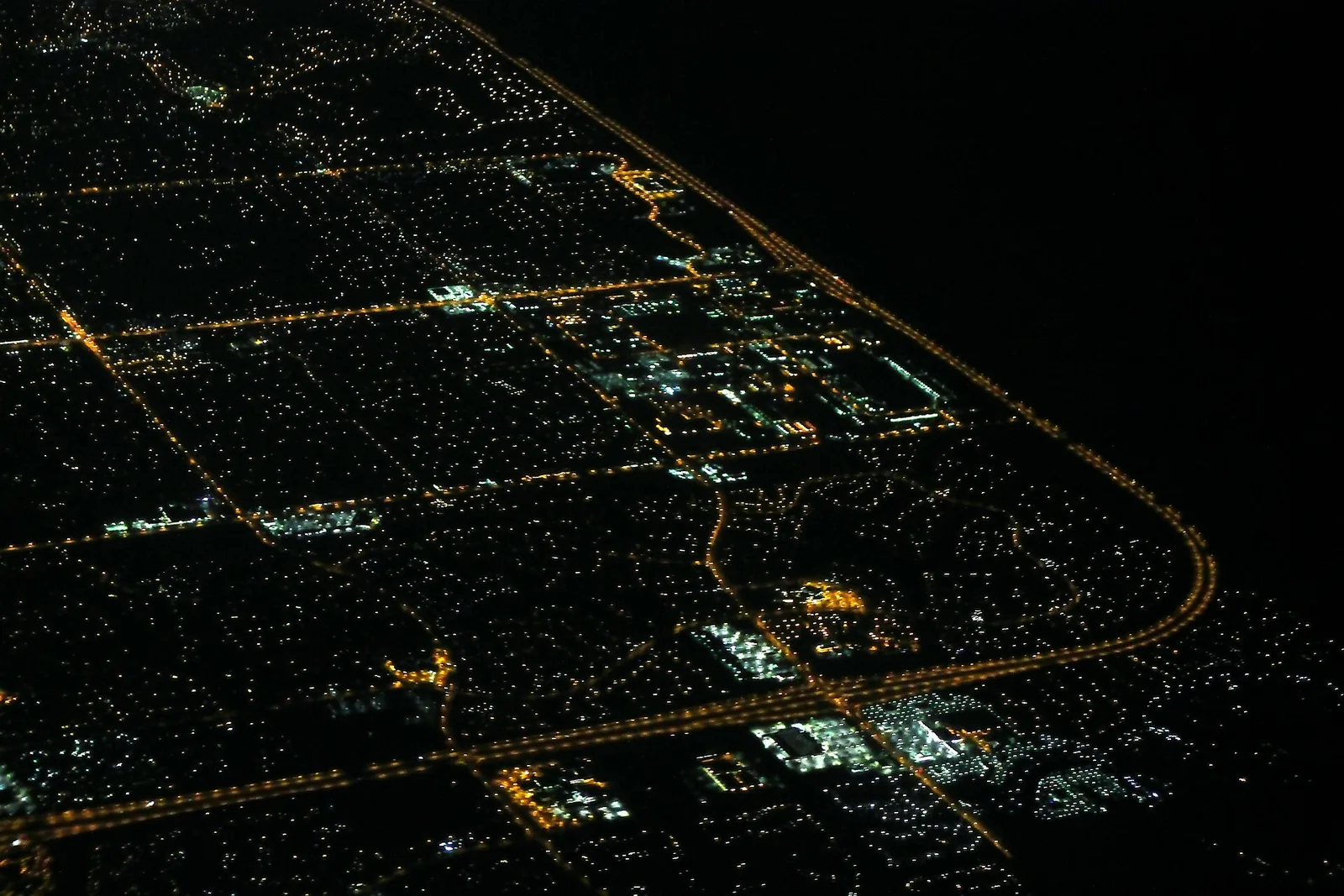 The lights of Coral Springs at night beside the dark Everglades, seen from the air